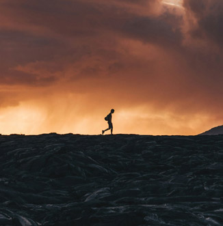 Silhouette of a boy traversing a lava field